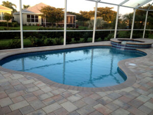 Screened pool with a hot tub at dusk