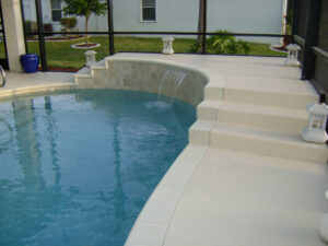 Pool with waterfall and beige deck