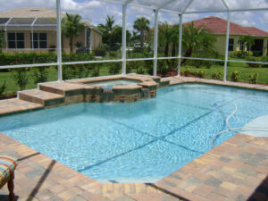 Screened pool with hot tub and tropical landscaping
