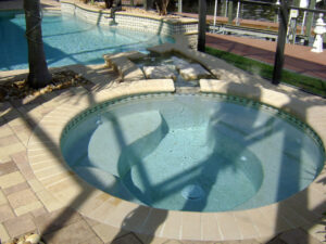 Circular spa with shadow of a palm on pool deck