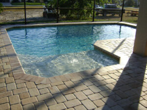 Screened patio with a clear pool and stone deck