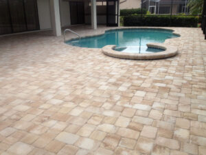 Curved pool and spa on large stone-tiled patio