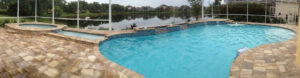 Panoramic view of a pool with a lake behind