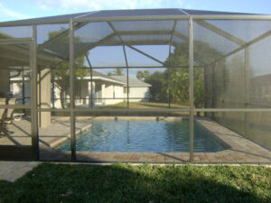 Enclosed backyard pool with lawn