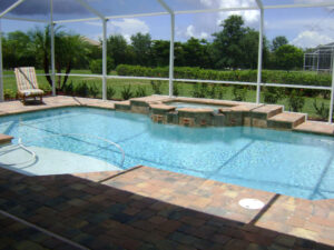 Pool with spa, chair, and greenery